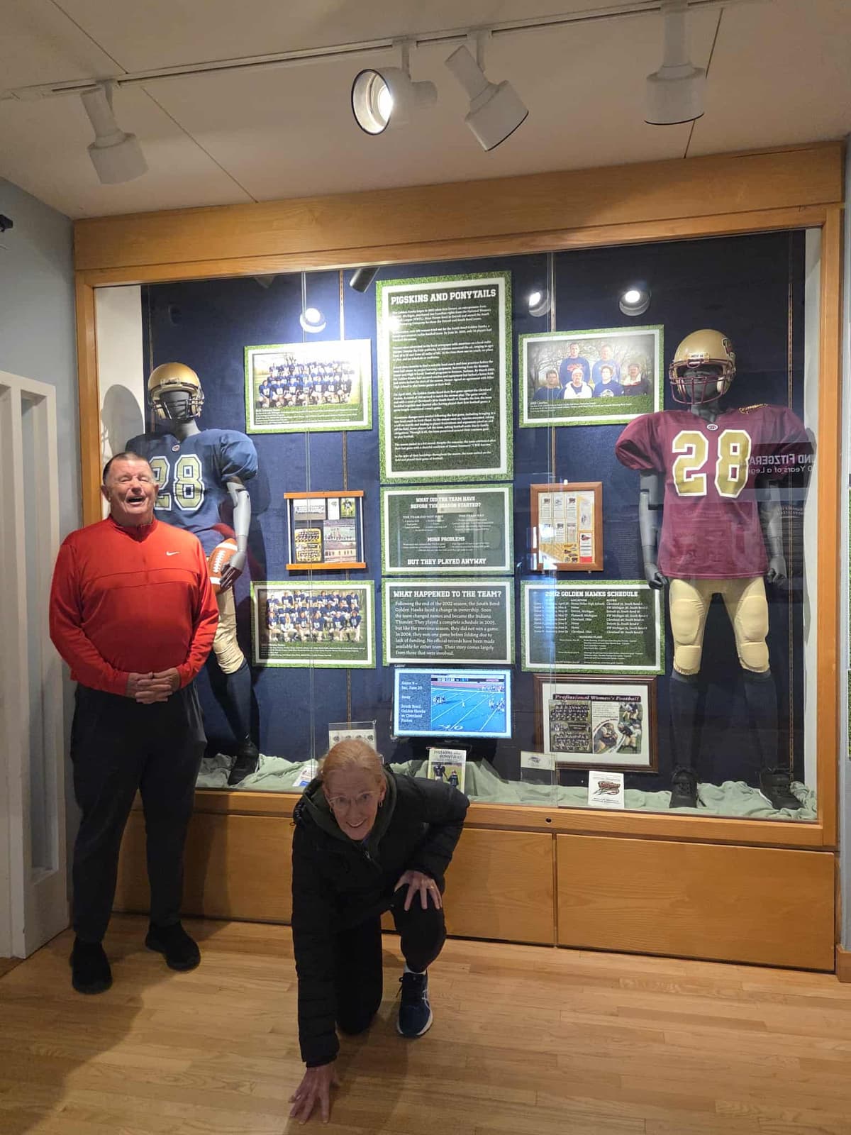 Mark Bradford and companion posing in front of the Pigskins and Ponytails museum exhibit