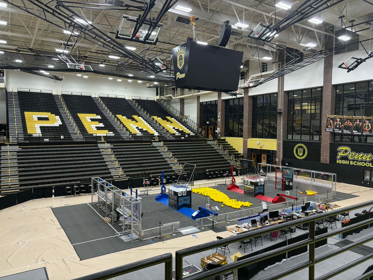 Penn High School gym set up for the FIN District Mishawaka FIRST Robotics Competition event, March 2026 — competition field with PENN lettering in the bleachers